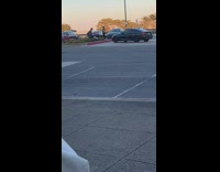 Guy squats red curb black car girl