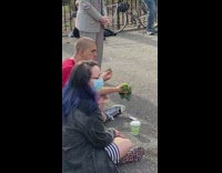 Guy holds and eats kale at park