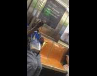 Man plays with small snake with golden snake cane on subway train