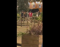 Four women tiktok dance while two men watches