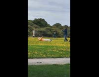 man orange jacket lays on flowers