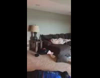 a guy in blue sets off fire crackers next to couch