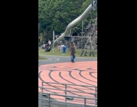 Collab IITW - Woman handstand for video at Seattle park white top blue leggings