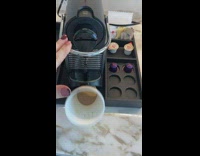 Woman uses coffee maker spills cup