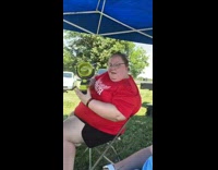 Woman in red shirt with yellow portable fan caught a vibe