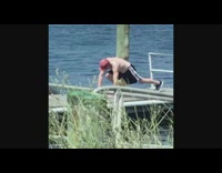 Guy red hat shirtless working out on pier dock water