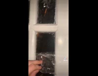 Guy peels off sticker on window glass 