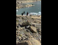 Man and woman tiktok dance near the rocks at the lake