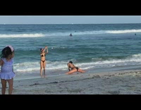 Woman black bikini split little girl beach