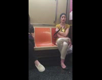 Woman red lipstick black headband scratches eye and makes funny weird face on the subway