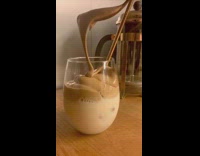 Spoon of cream poured in dalgona coffee