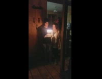 Girl blows out candles while guy holds cake guy drops cake