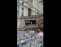 Woman stands on stairs barrier while the guard stops her