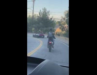 Black helmet girl stands motorcycle selfie sunset