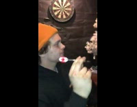 Guy uses stomach as dartboard yellow beanie 