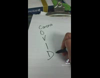 Person writes COVID acronym 
