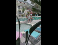 Woman sit chair hold drink pool side