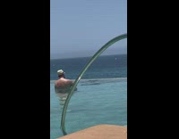 Man shirtless emerges from the swimming pool