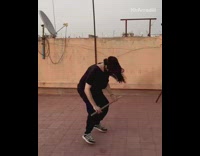 Guy holds stick jumps over and back 