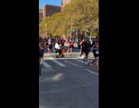 Old woman in scooter crosses marathon road