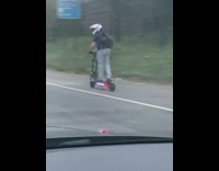 Daredevil New Yorker rides an electric scooter down busy highway