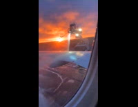 Deicing machine spray on plane wing sunset