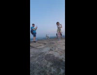 White shirt brown pants girl giant rock