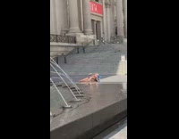 Blue chair lady tans outside water fountain 
