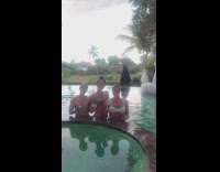 Girl jumps on inflatable swan and scorpions into swimming pool behind girlfriends with drinks