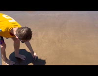 Boy use pipe suck shrimp from sand