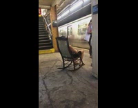 Woman carries brown chair into train 