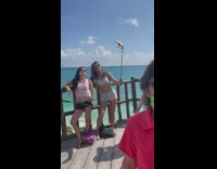 Two women selfie stick on the beach near the crowd
