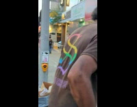 Man in white shirt reviews the pizza on the sidewalk