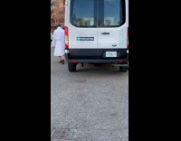 Guy in Long White Robe Walks on Street 