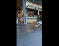 Girl grabs coffee from pastry case 