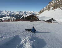 Blue jacket rides snowboard, flips over small hump and faceplants snow