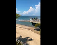 Slowmo of guy flipping off high platform onto beach