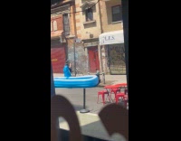 Woman setting up inflatable pool and floater on street 