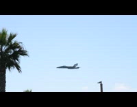 Jet plane flyby fast near the trees on the street