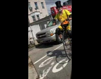 Guy rides bike with one big wheel and small wheel in yellow 