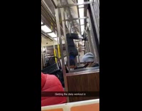 Guy does sit ups on metal bar 