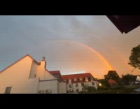 Lightning strike on sky with  partial double rainbow