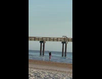 Lady Does Poses on Beach by Pier