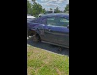 Parked blue car no wheels with scratches