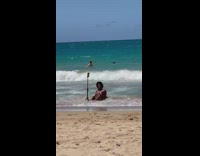 Woman in a thin bikini lie down on the beach shore