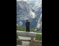 Guy glasses black robe stand blocks mountain