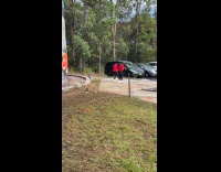 Two women red jacket dances parking lot