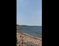 Woman green bikini arch back parachutes beach