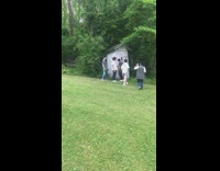 Four men poses in front of the bathroom from Shrek