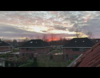 Guy watches red sunset over neighborhood 